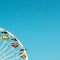 Iconic Ferris wheel at Santa Monica Pier beneath a bright blue sky, perfect for summer travel imagery.